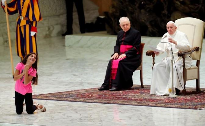 فتاة ترقص وتصفق على المسرح أثناء إلقاء البابا فرنسيس عظة في الفاتيكان يوم الأربعاء. تصوير: ريمو كاسيلي - رويترز